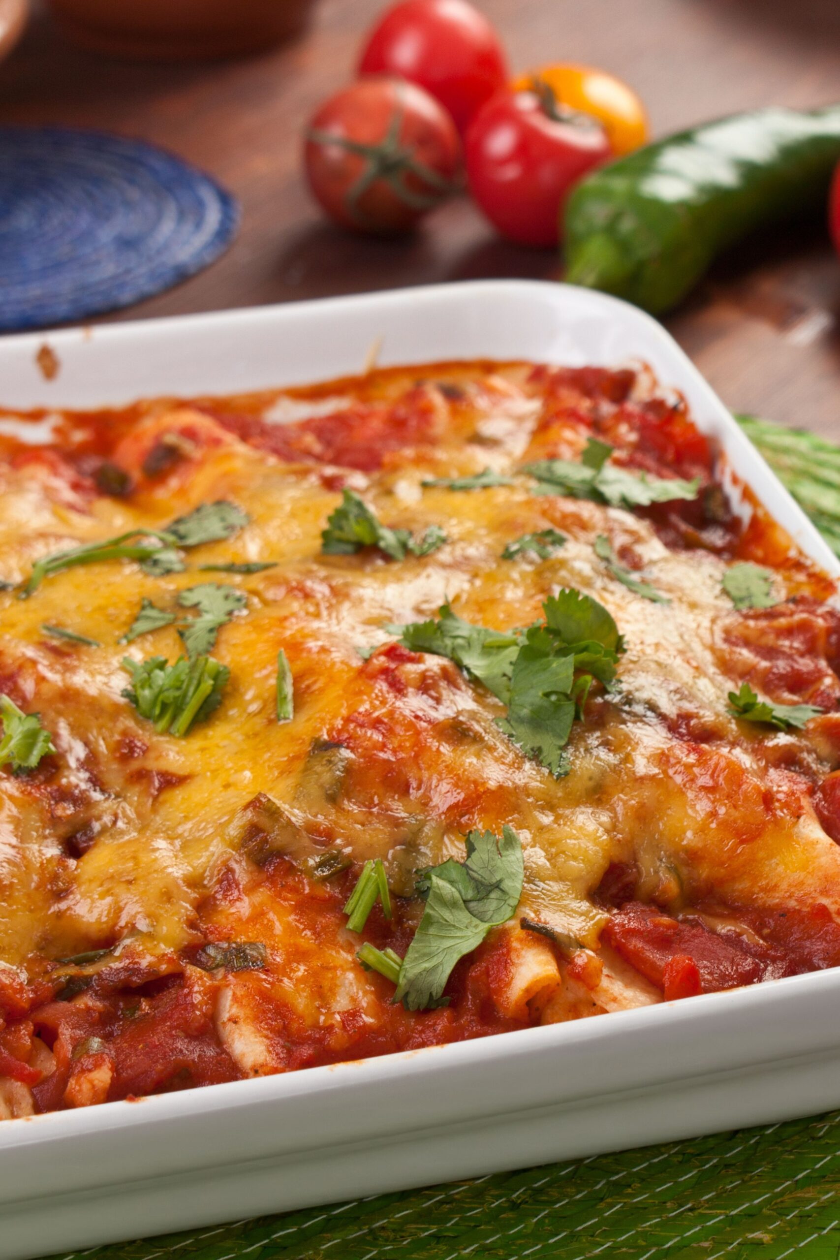 Weight Watchers Chicken Taco Casserole in a white casserole dish. Fresh red and green peppers in the background.