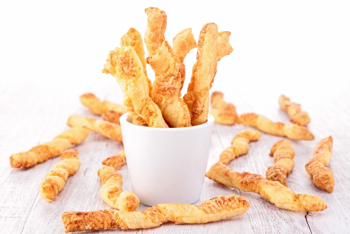 Weight Watchers Crispy and Spicy Cheese Twists standing up in a white cup.