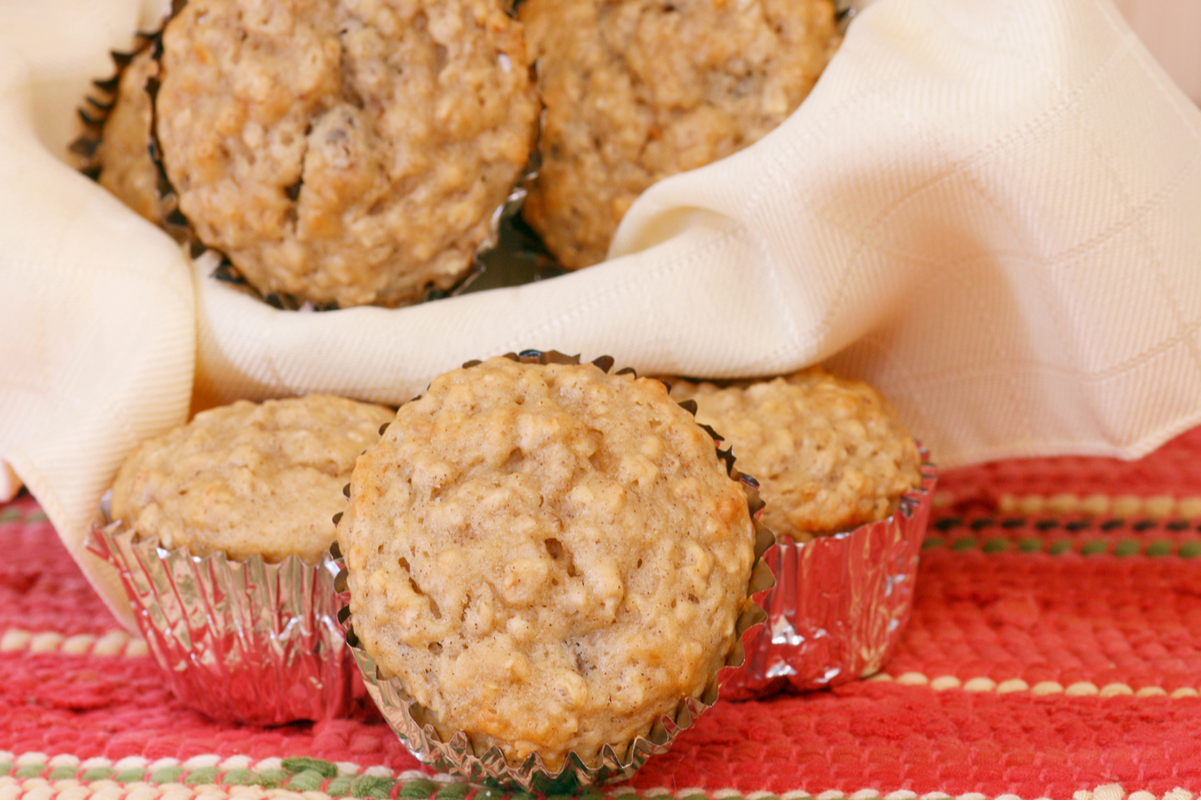 Weight Watchers Apple Oatmeal Muffins in a basket lined with a cloth napkin, sitting on a red table cloth.