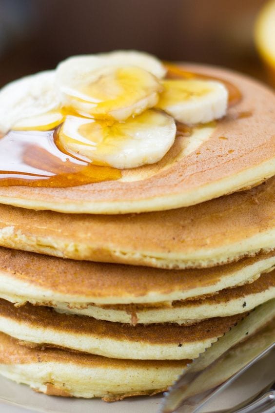 Stack of pancakes topped with bananas