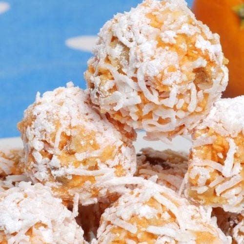 A pile of Coconut Date Balls with a blue background.