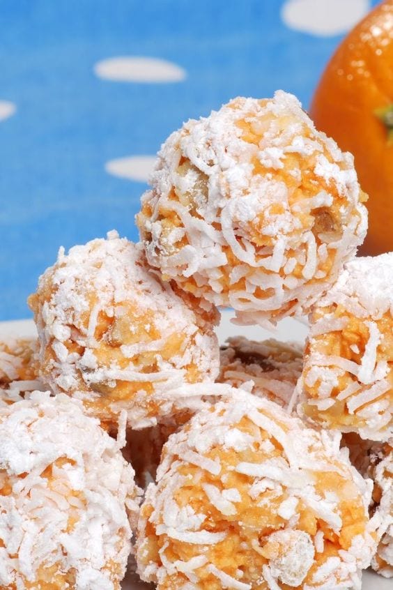  Weight Watchers Coconut Date Balls arranged in a pile with a blue background