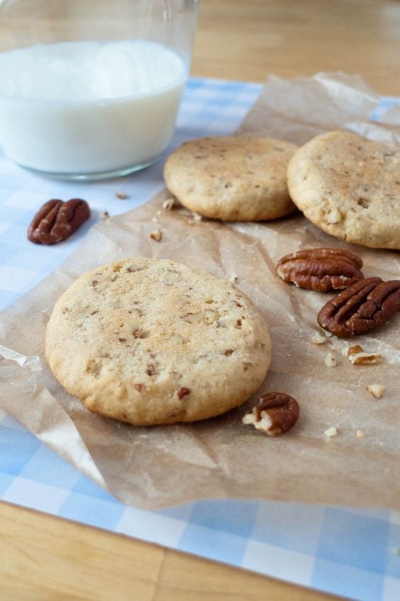 Weight Watchers Pecan Sandies with a glass of milk and whole pecans around it.