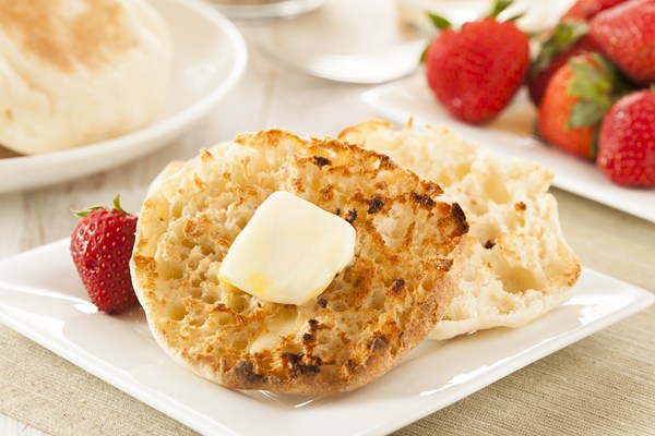 Homemade Weight Watchers English Muffin with a pat of butter, sitting on a square, white plate, with strawberries.