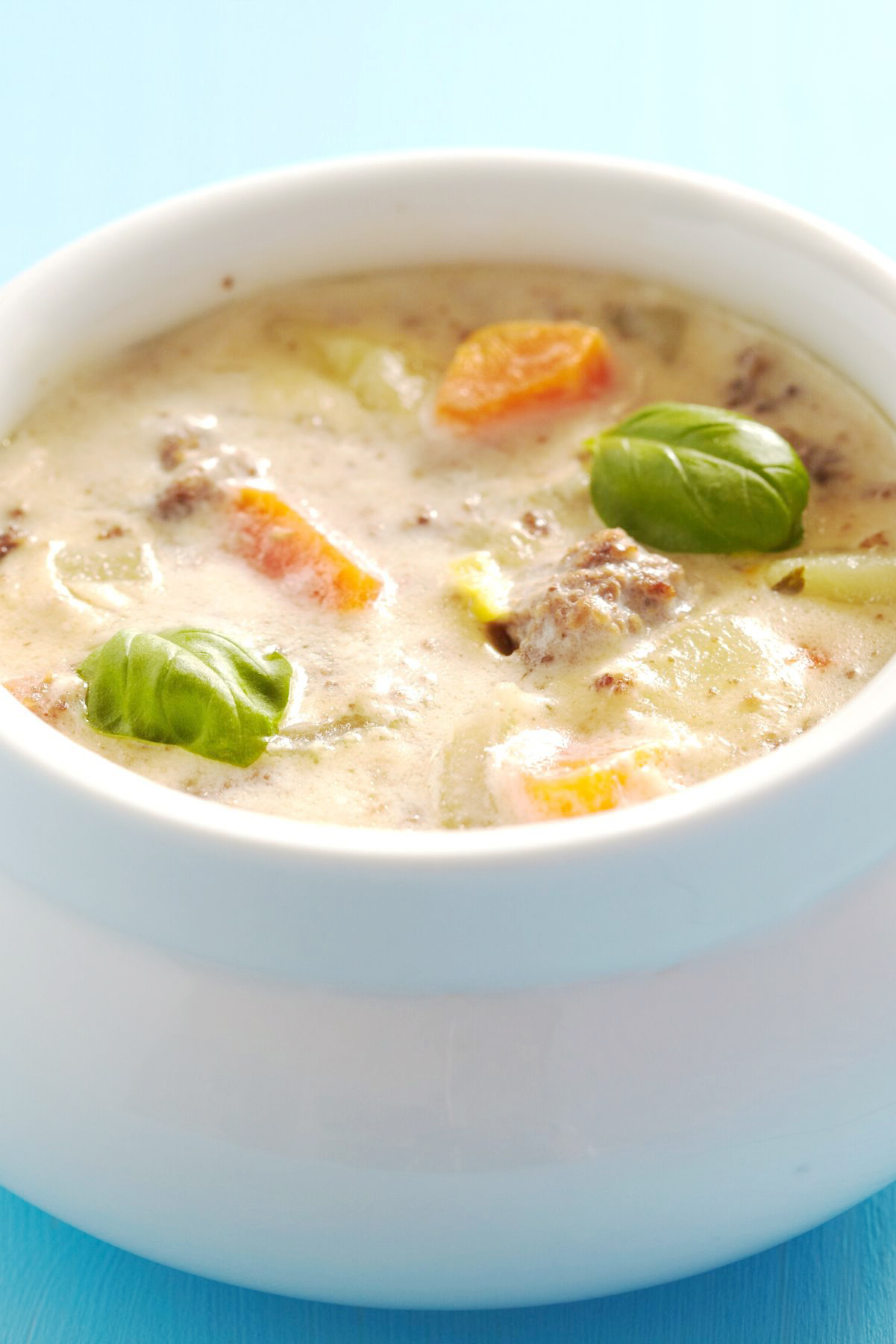 Closeup of Weight Watchers Cheeseburger Soup in a white crock.