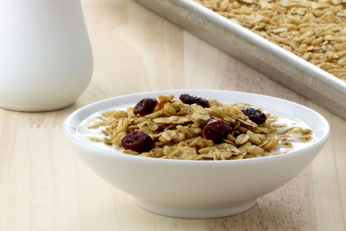 Weight Watchers Homemade Granola in a white bowl with a white pitcher of milk behind it.