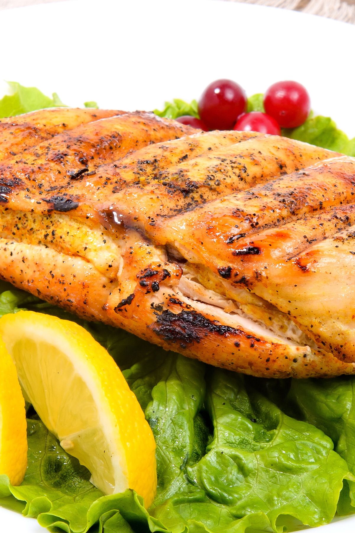 Closeup of Weight Watchers Jalapeno Chicken on a bed of lettuce, on a white plate.