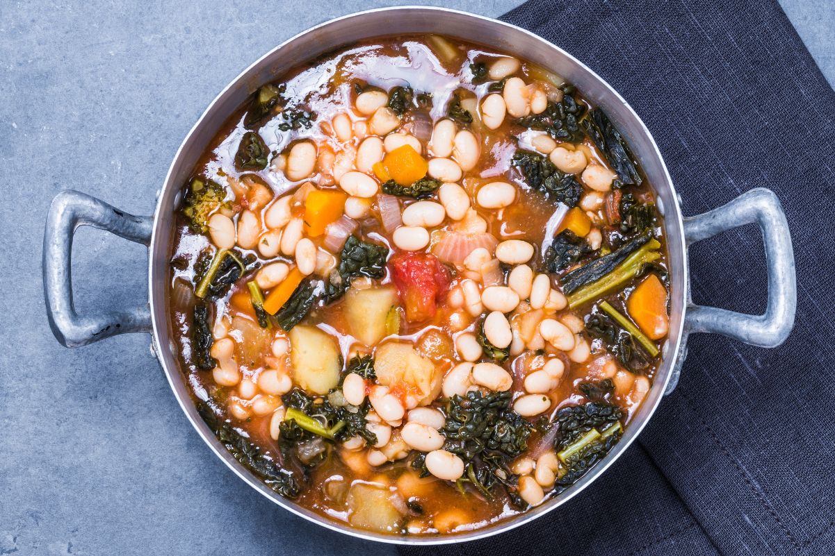 Healthy Vegetarian Weight Watchers Kale Soup Recipe in a cooking pot sitting on a gray cloth and gray surface.