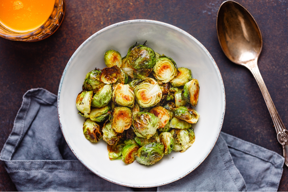 Simple Weight Watchers Instant Pot® Brussels Sprouts in a white bowl with a spoon next to it.