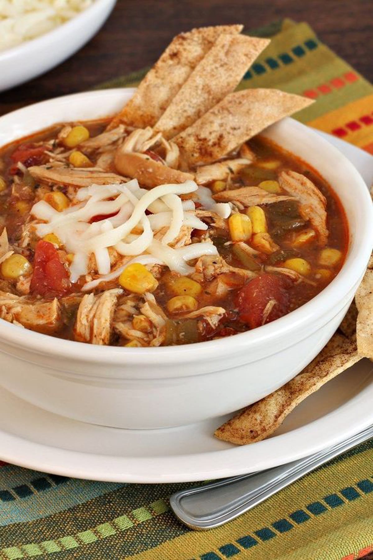 Weight Watchers Chicken Tortilla Soup in a white bowl, sitting on a colorful placemat.