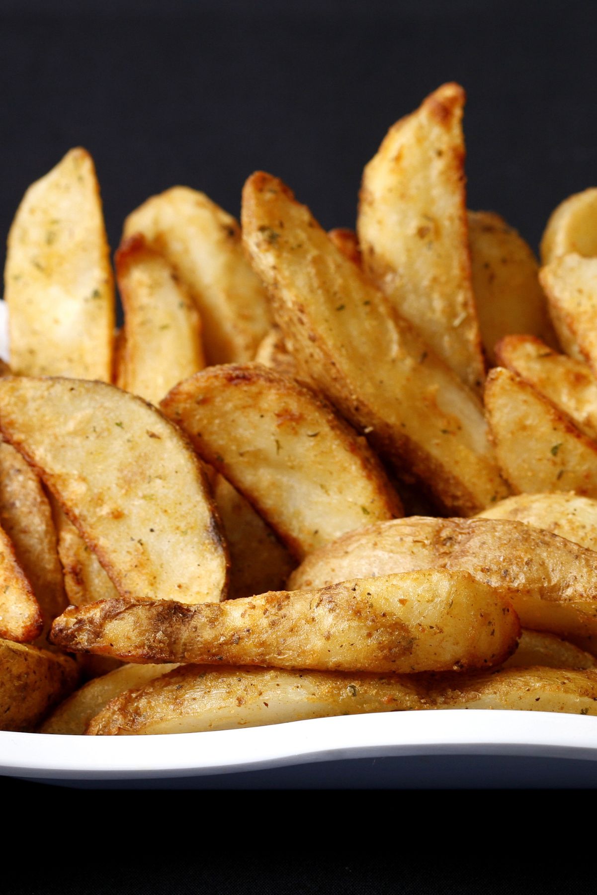 Closeup of Weight Watchers Spiced French Fries with a black background.