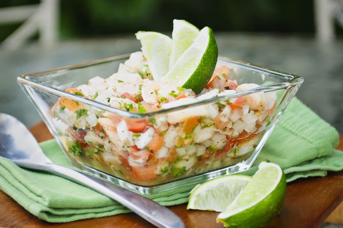 Weight Watchers Avocado and Shrimp Ceviche in a clear glass bowl. with sliced fresh lime next to it.