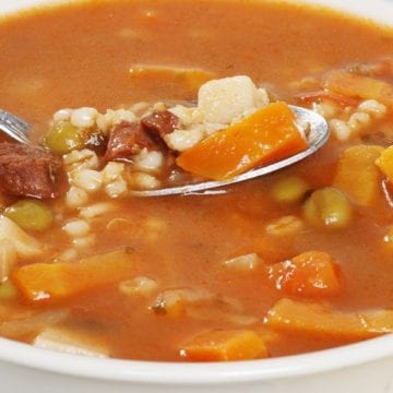 Weight Watchers Beef and Barley Soup in a white bowl with a spoon.