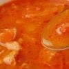 Closeup of Healthy Weight Watchers Cabbage Soup in a white bowl with a spoon in it.