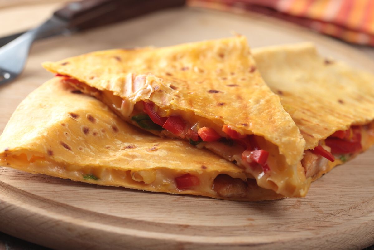 Weight Watchers Crab Quesadillas stacked on a round, wooden cutting board.