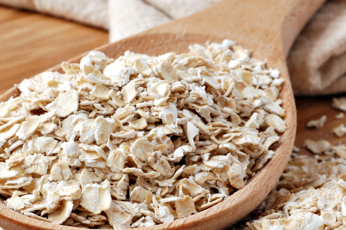Closeup of quick oats on a wooden spoon.