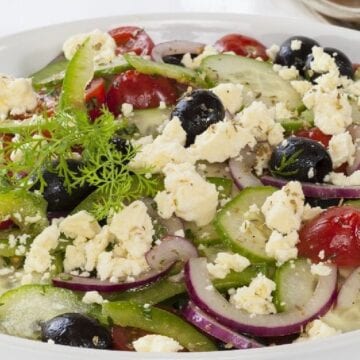 Weight Watchers Greek Salad in a white bowl on a white table.
