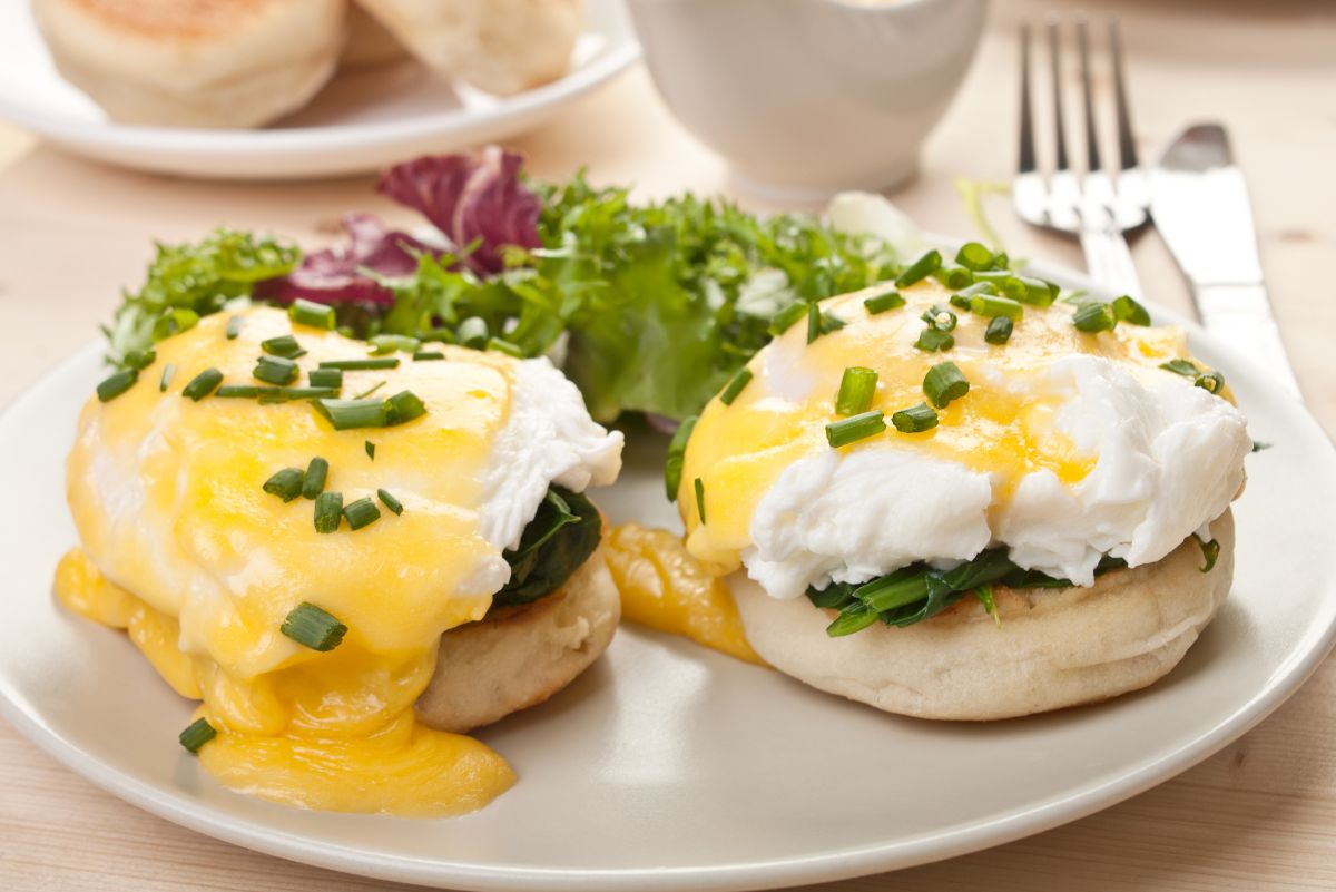 2 Weight Watchers Eggs Benedict on a white plate with flatware behind it.