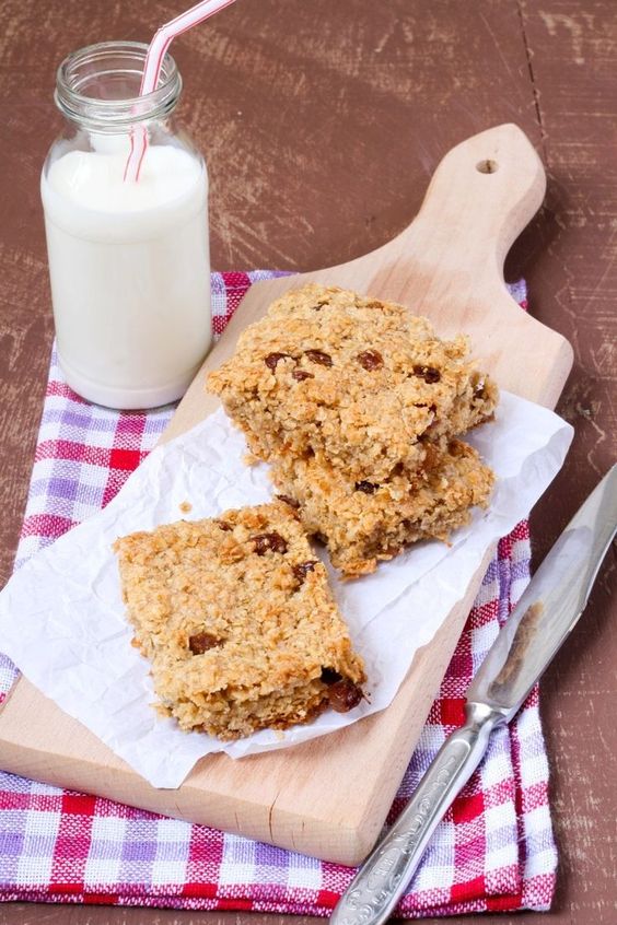 Weight Watchers No-Bake Granola Bars on a cutting board with a glass of milk next to it.