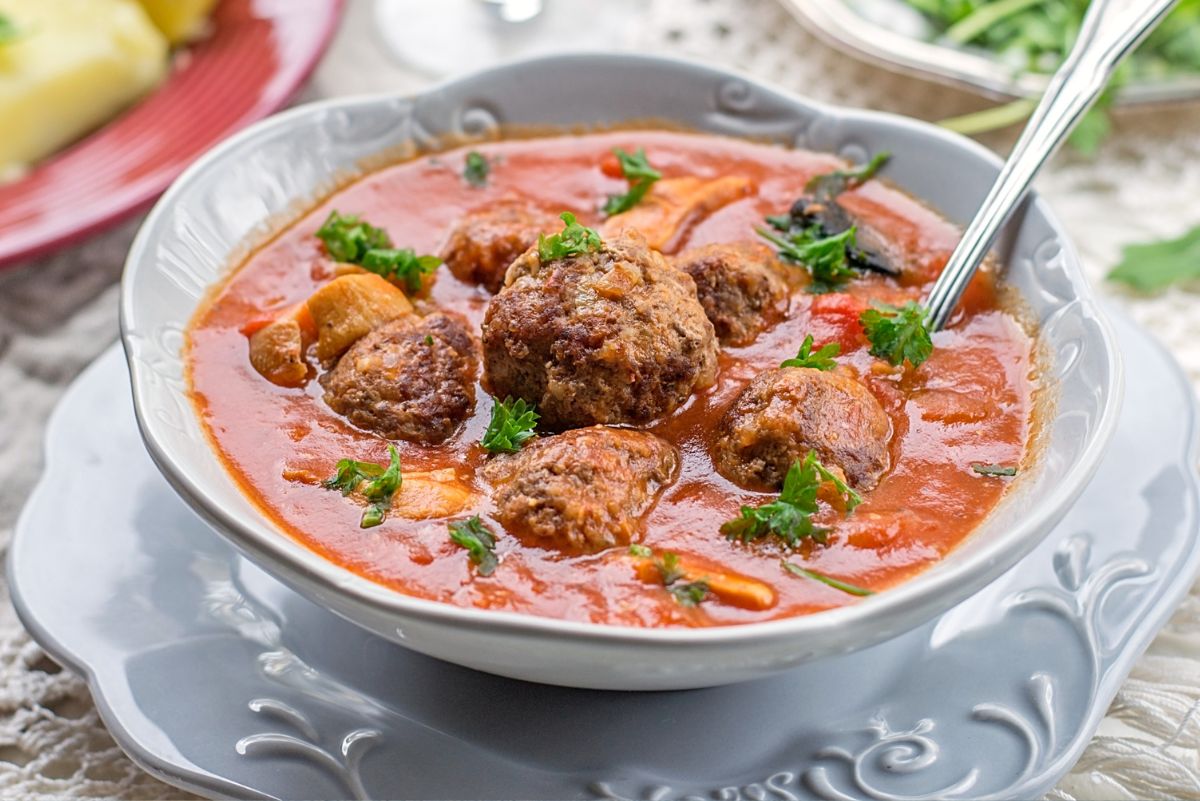 Weight Watchers Mexican Meatball Soup in a white bowl with a spoon in it.