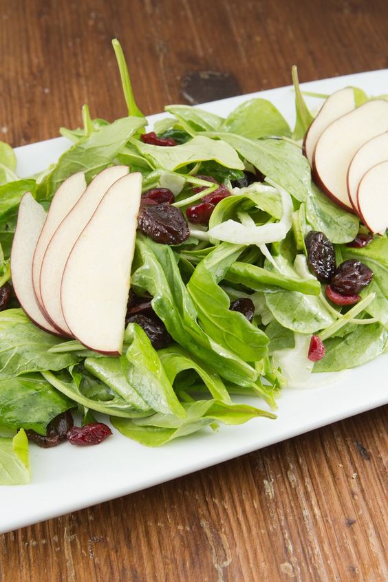 Closeup of Weight Watchers Cranberry Pear Salad on a white plate sitting on a wooden table.