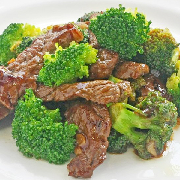 Beef and broccoli stir fry on a white plate.
