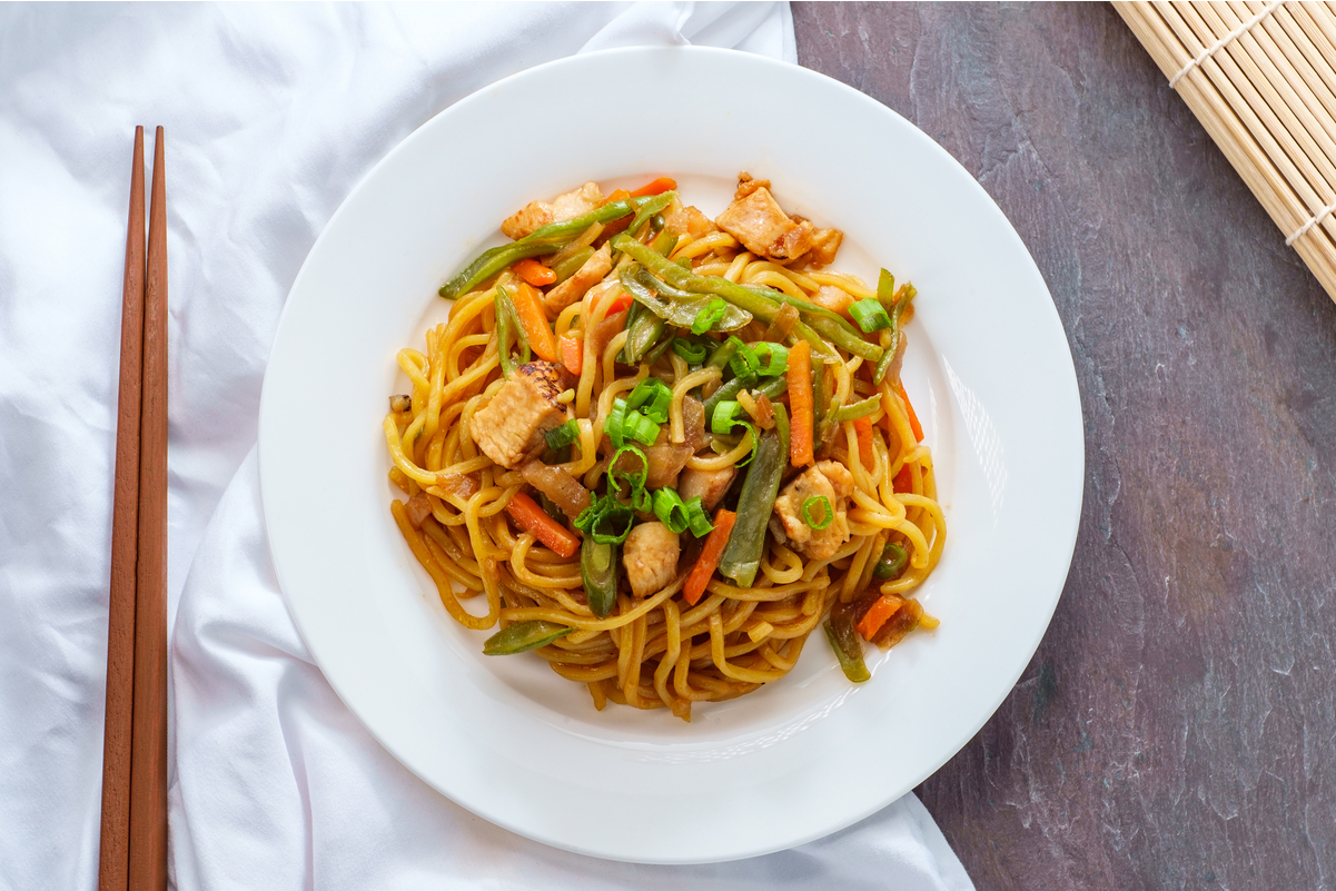 Weight Watchers Chinese Chicken lo Mein on a white plate with a pair of chopsticks next to it.