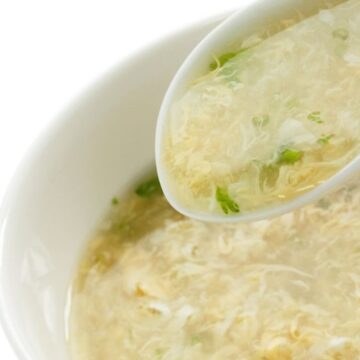 Weight Watchers Egg Drop soup in a white bowl, with a white spoon in it.