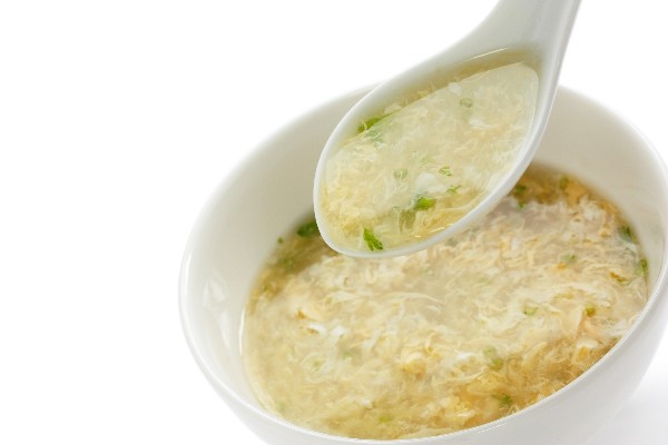 Weight Watchers Egg Drop Soup in a white bowl with a spoonful of soup above it.