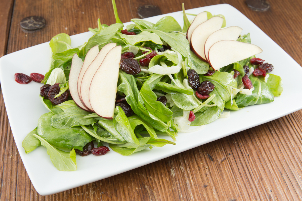 Weight Watchers Cranberry Pear Salad on a white, rectangular plate on a wooden table.