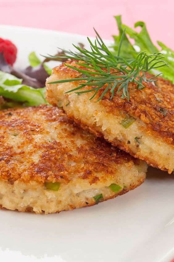Two crab cakes on a white plate.