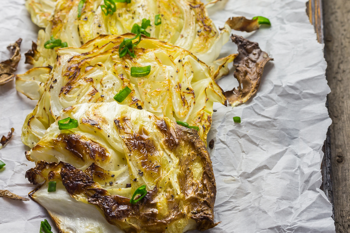 Roasted Cabbage Wedges on a wooden cutting board.