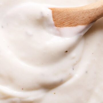 Closeup of Weight Watchers Bechamel Sauce with a wooden spoon in it.