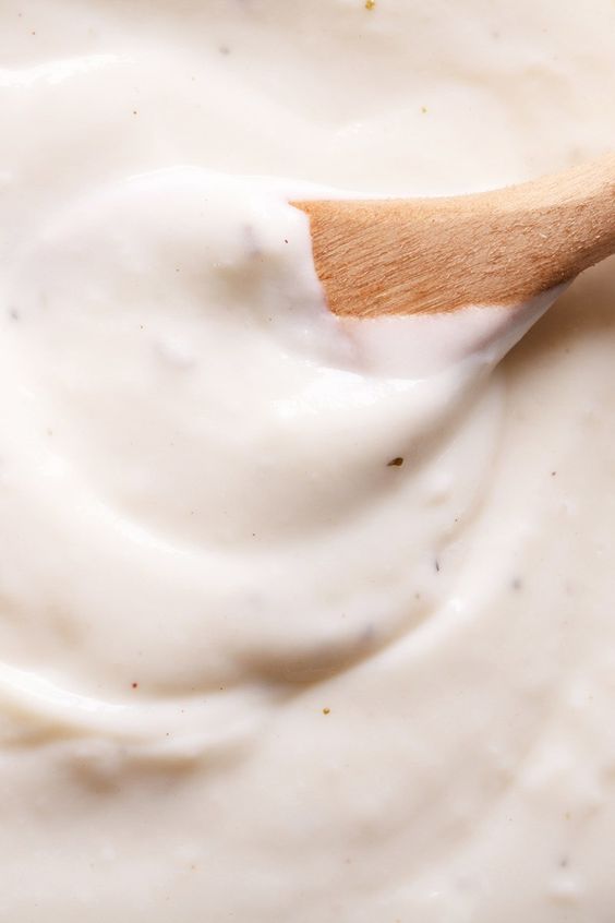Closeup of Weight Watchers Bechamel Sauce with a wooden spoon in it.