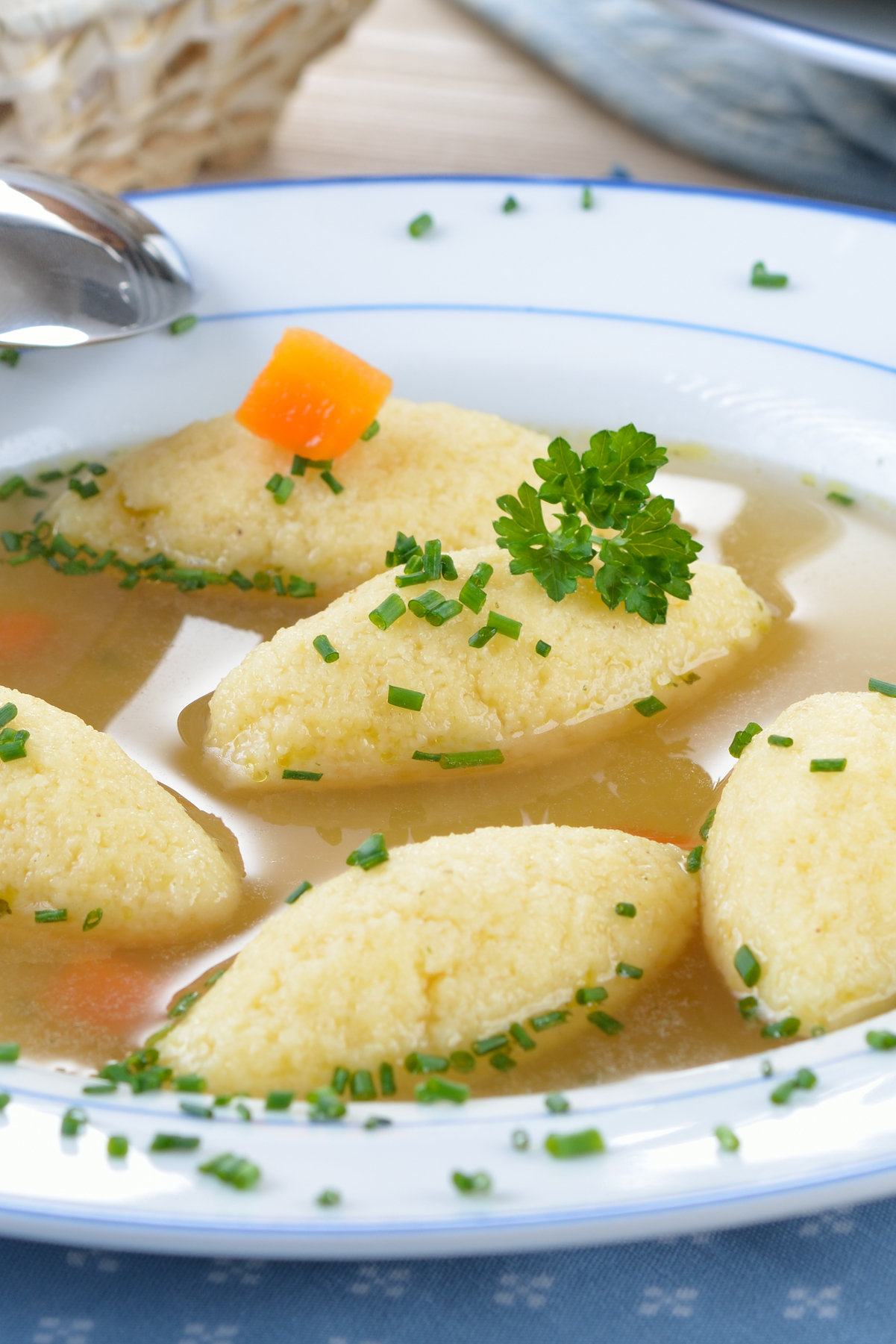 Dumplings in a white bowl with broth.