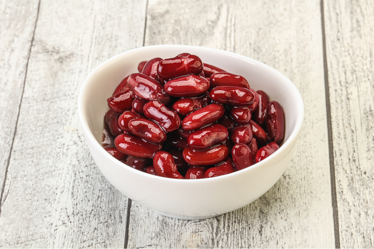 Kidney Beans in a white bowl, on a rustic surface.