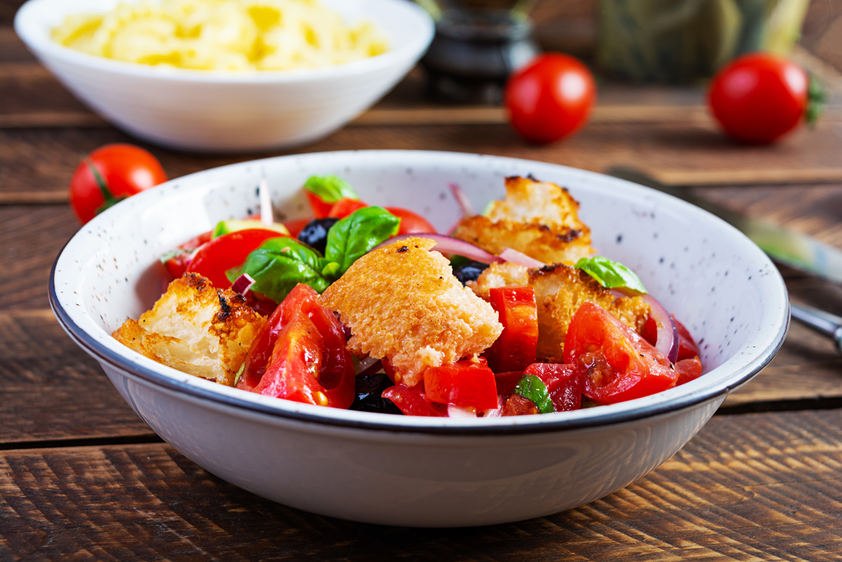 Weight Watchers Tomato Salad with Grilled Italian Bread in a white bowl, on a wooden table.