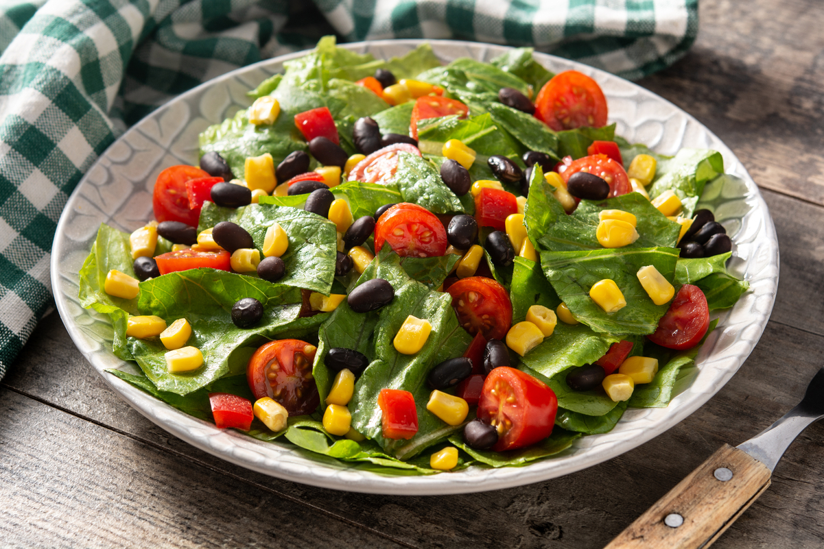 Weight Watchers Mexican Black Bean Vegetable Salad in a white bowl with a green and white checked cloth behind it.