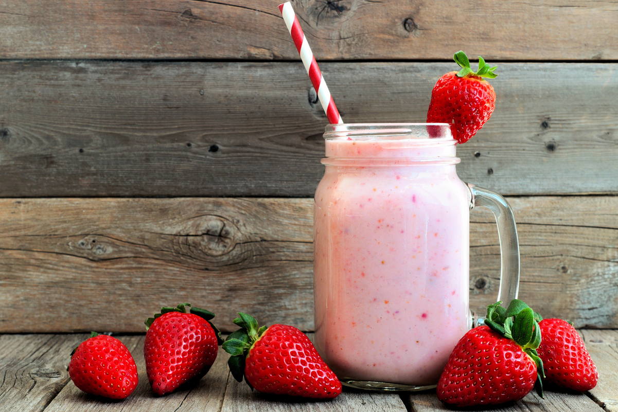 Weight Watchers Strawberry Vanilla Protein Shake in a glass with strawberries around it.