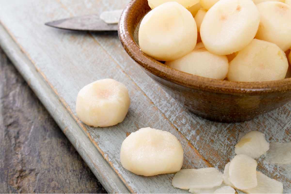 Water chestnuts in a bowl on a rustic table.