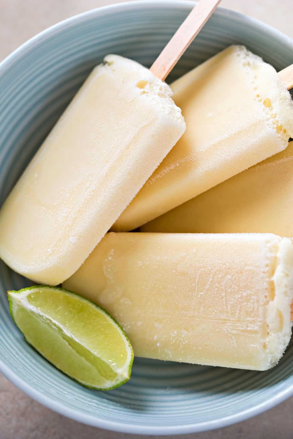 Closeup of Creamy Weight Watchers Key Lime Popsicles in a blue bowl.
