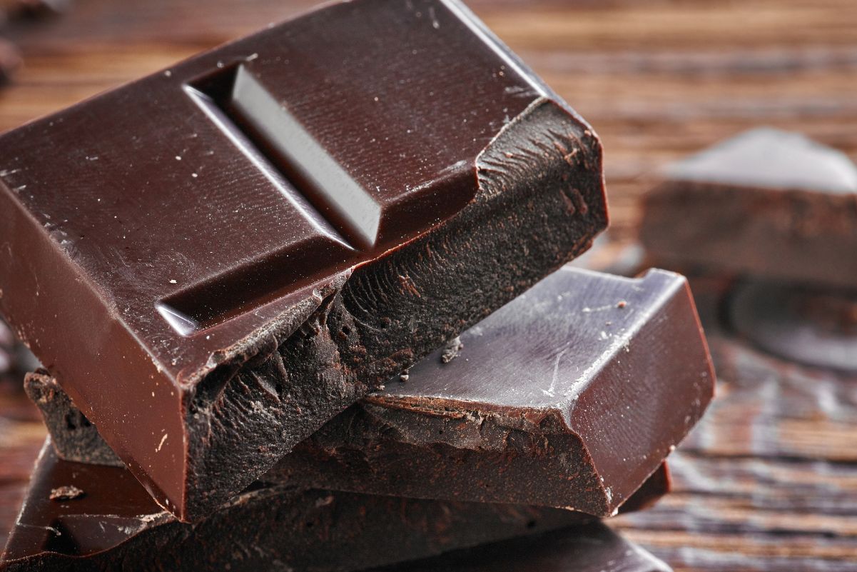 Pieces of dark chocolate on a rustic surface.