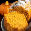 Pumpkin cake with a pumpkin decoration behind it.