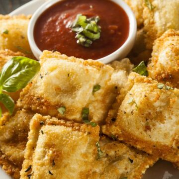 Closeup of Weight Watchers Baked Ravioli with Marinara Sauce on a white plate.