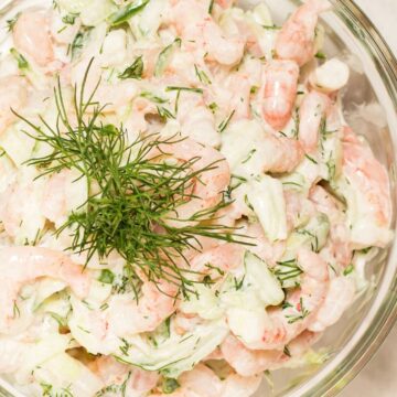 Closeup of Weight Watchers Dill Shrimp Salad Sandwich with Cucumber in a clear glass bowl.