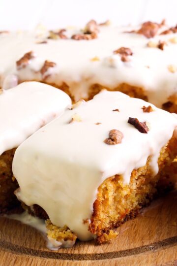 Closeup of slices of Slow Cooker Weight Watchers Carrot Cake on a wooden cutting board.