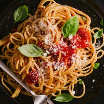 Overhead view of Weight Watchers Spaghetti Pomodoro on a black surface.