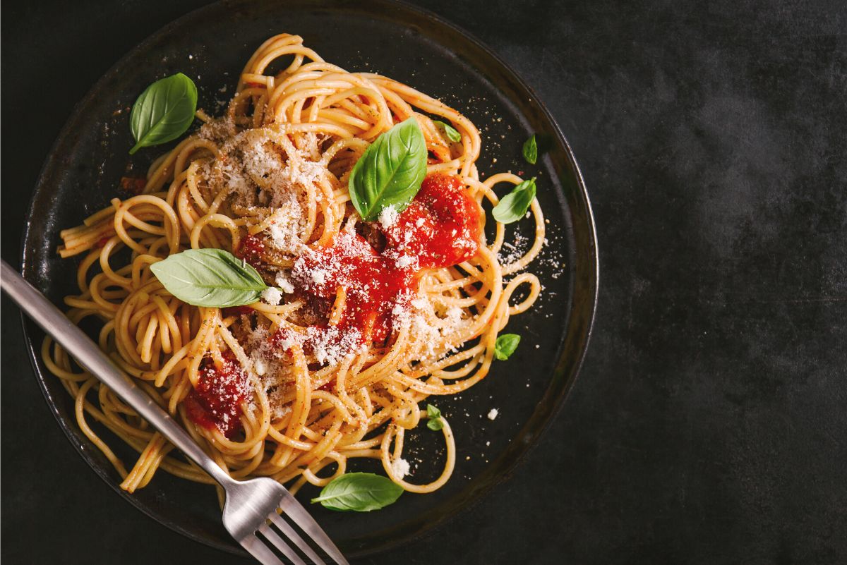 Over head view of Weight Watchers Spaghetti Pomodoro on a black surface with a fork laying across the black plate.