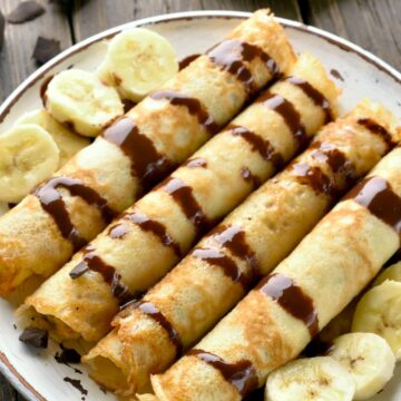 Weight Watchers Chocolate Peanut Butter Crepes on a white plate with sliced bananas.