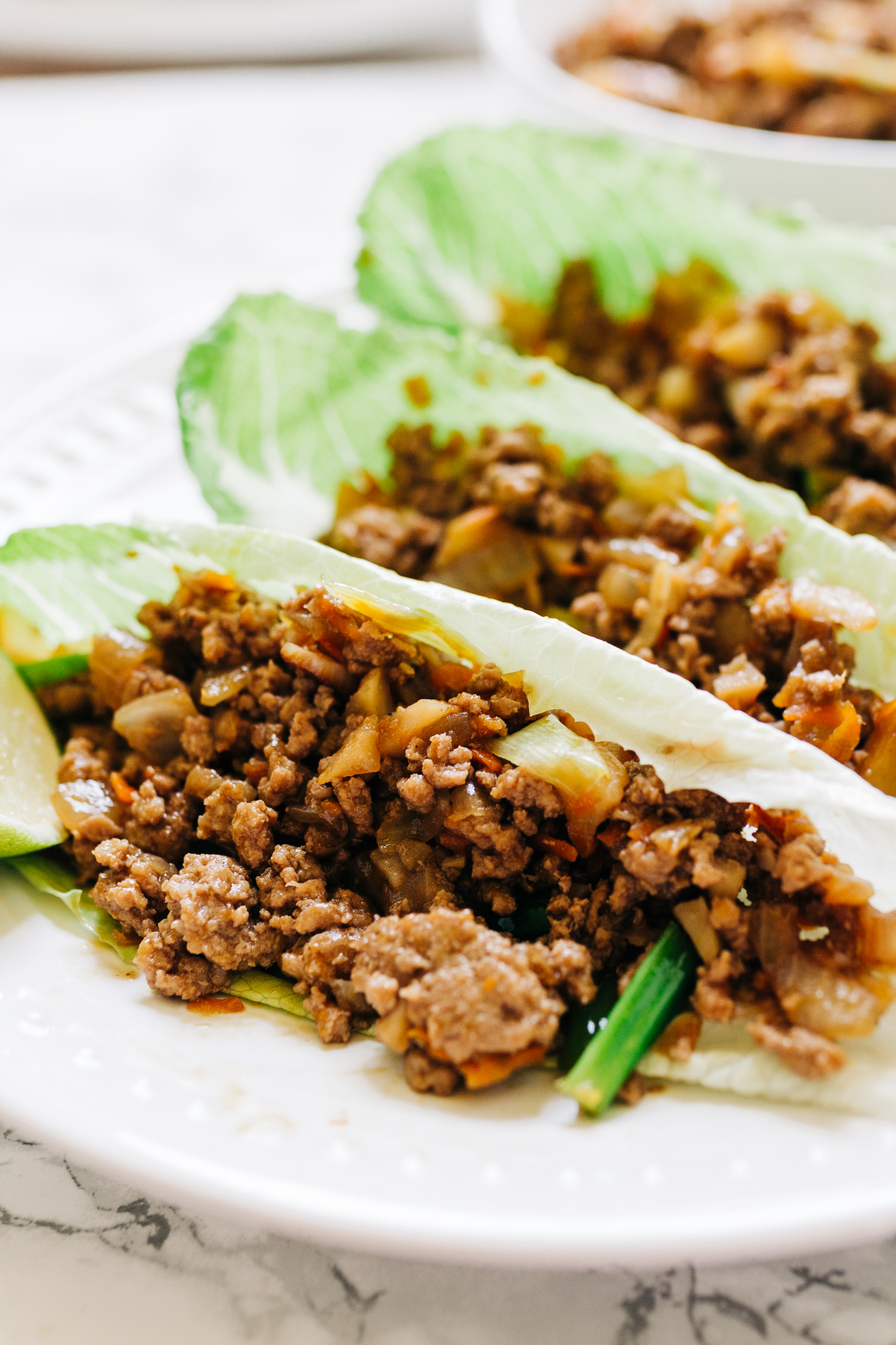 Closeup of Weight Watchers Ginger Beef Lettuce Wraps on a white surface.